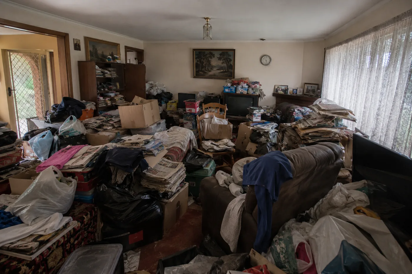 The same living room before, filled with hoarded belongings